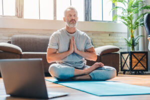hombre meditando en casa para reducir el estrés