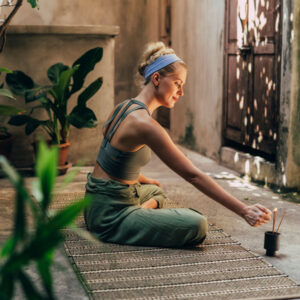mujer encendiendo incienso para comenzar a hacer yoga