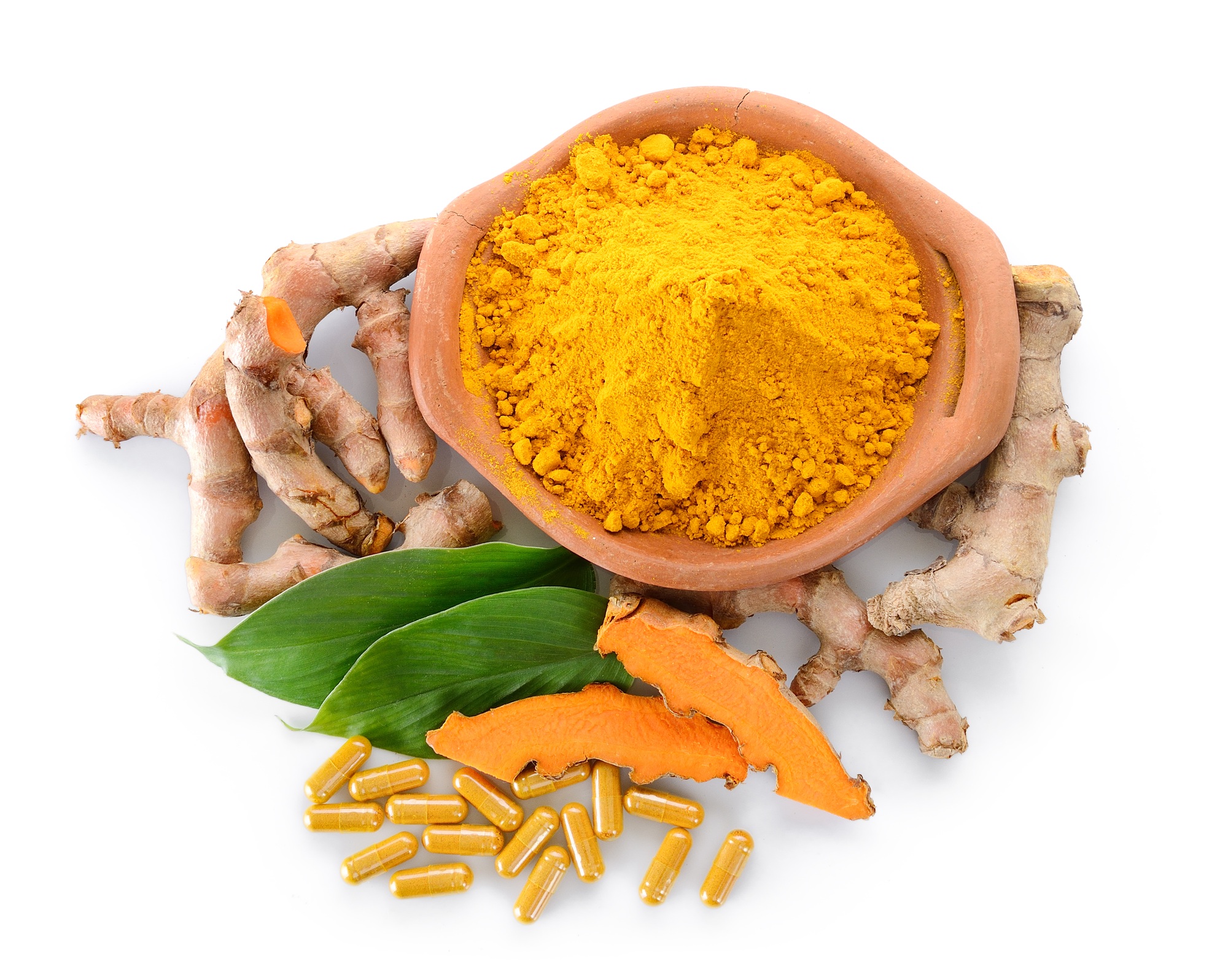 Turmeric powder and turmeric capsules on white background
